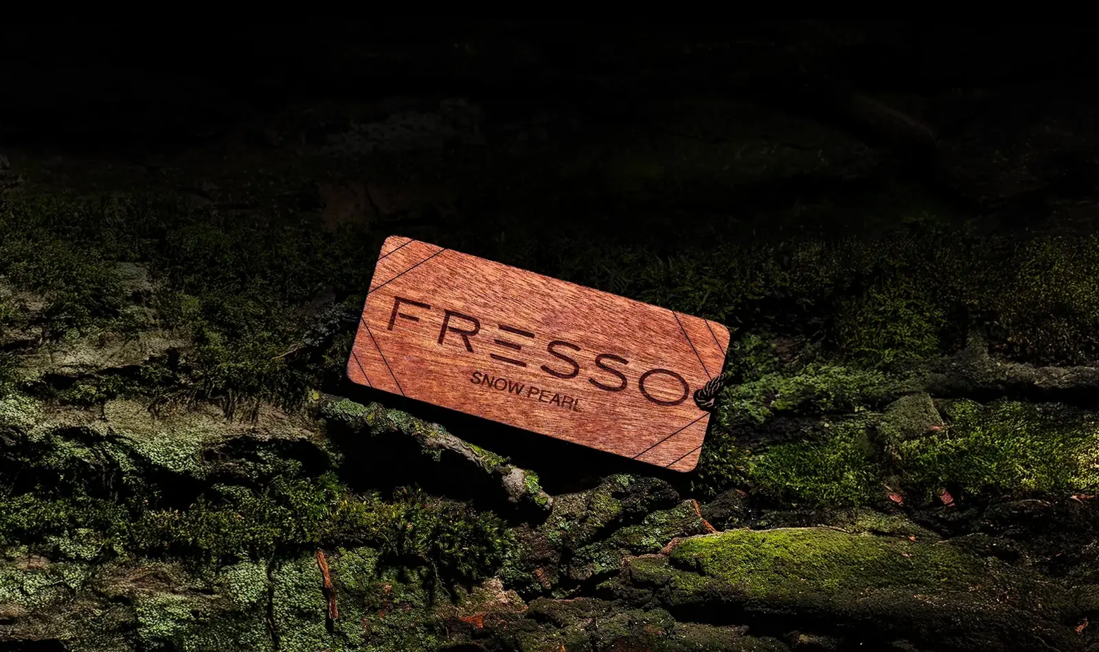 Hölzerner FRESSO Snow Pearl Duftanhänger auf bemoostem Holz